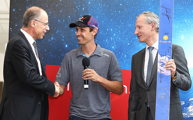 TÜV AUSTRIA begrüßt mit Kunden und Partnern den Sommer: dreifachen Olympia-Bronze-Medaillengewinner Lukas Klapfer überreicht seinen Sprungski dem Vorstand der Unternehmensgruppe.
