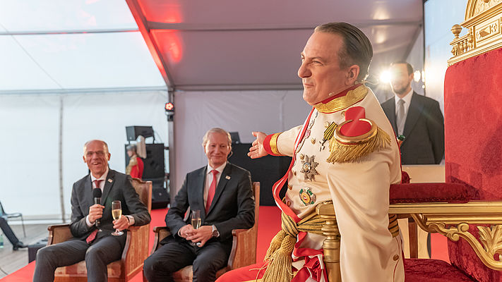 [Translate to Türk:] A visit by “Emperor Robert Heinrich I” (actor Robert Palfrader) caused a sensation and a great deal of merriment among the guests at the event. The visiting sovereign was highly astonished and impressed by the constant further development of the Austrian pioneer of steam boiler safety into a digital, sustainable company with international operations: (l.t.r.) Christoph Wenniger, CFO, Stefan Haas, CEO TÜV AUSTRIA Group, Robert Palfrader as Emperor Robert Heinrich I  (C) TÜV AUSTRIA, Rainer Hackstock